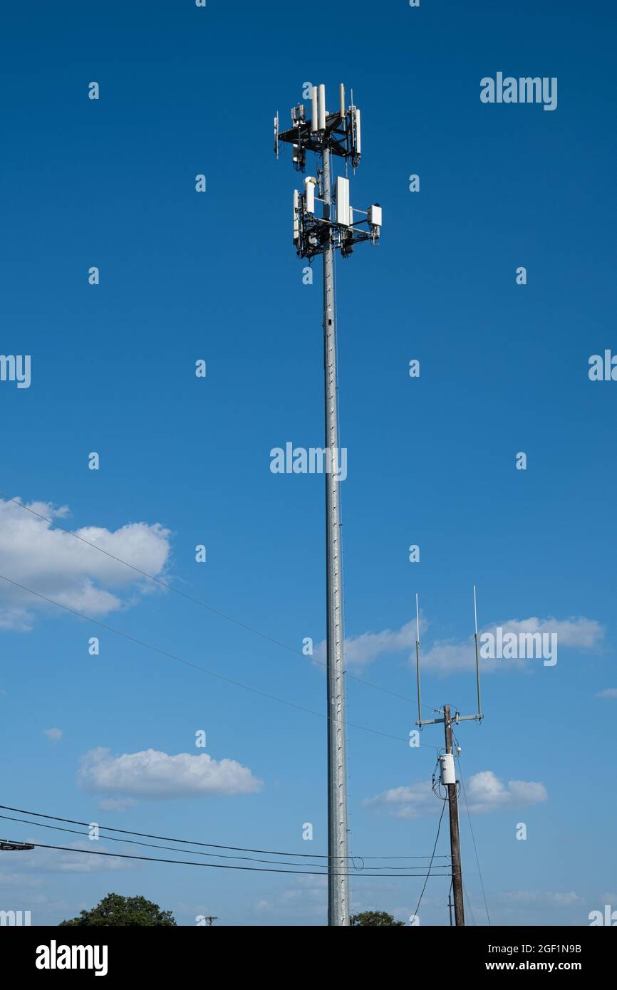 Two wireless communications towers close to reach other. One is cellular the other for radio. Stock Photo