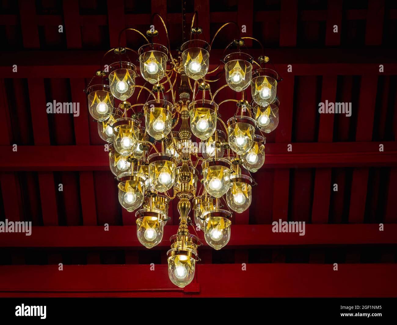 Vintage old light bulbs, gold chandelier hanging on the red ceiling in