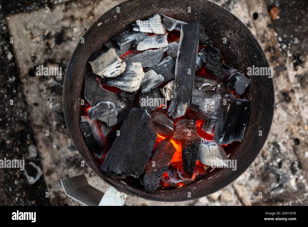 Hardwood lump charcoal smolders in a chimney prior to use for grilling Stock Photo Alamy