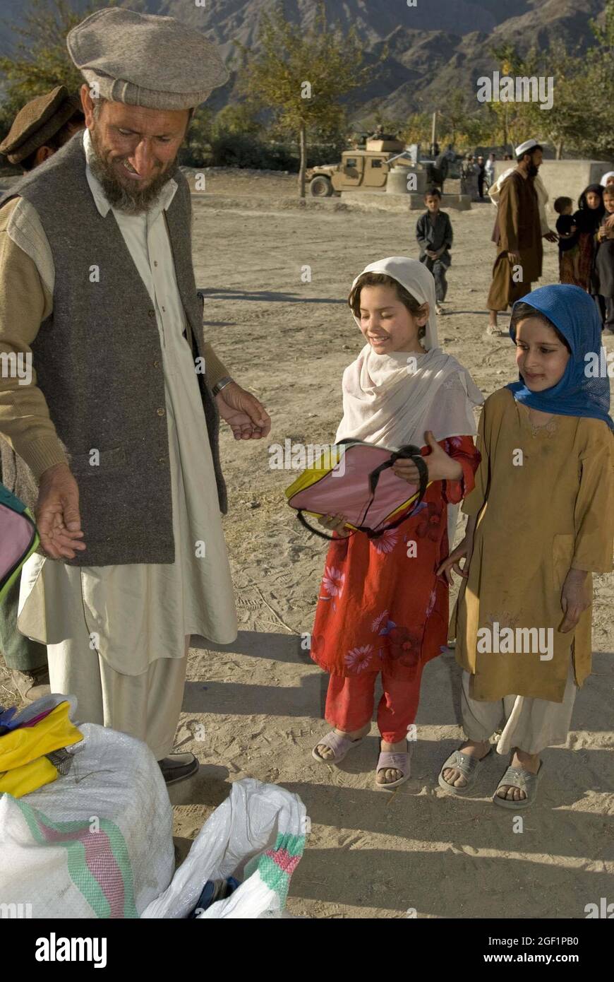 Narang Sub-Governor Haii Tahulam hands out school supplies, Dec. 4, donated by Destined Company, 2nd Battalion, 503rd Infantry Regiment (Airborne), at a school in Bar Narang, Kunar Province, Afghanistan. Stock Photo