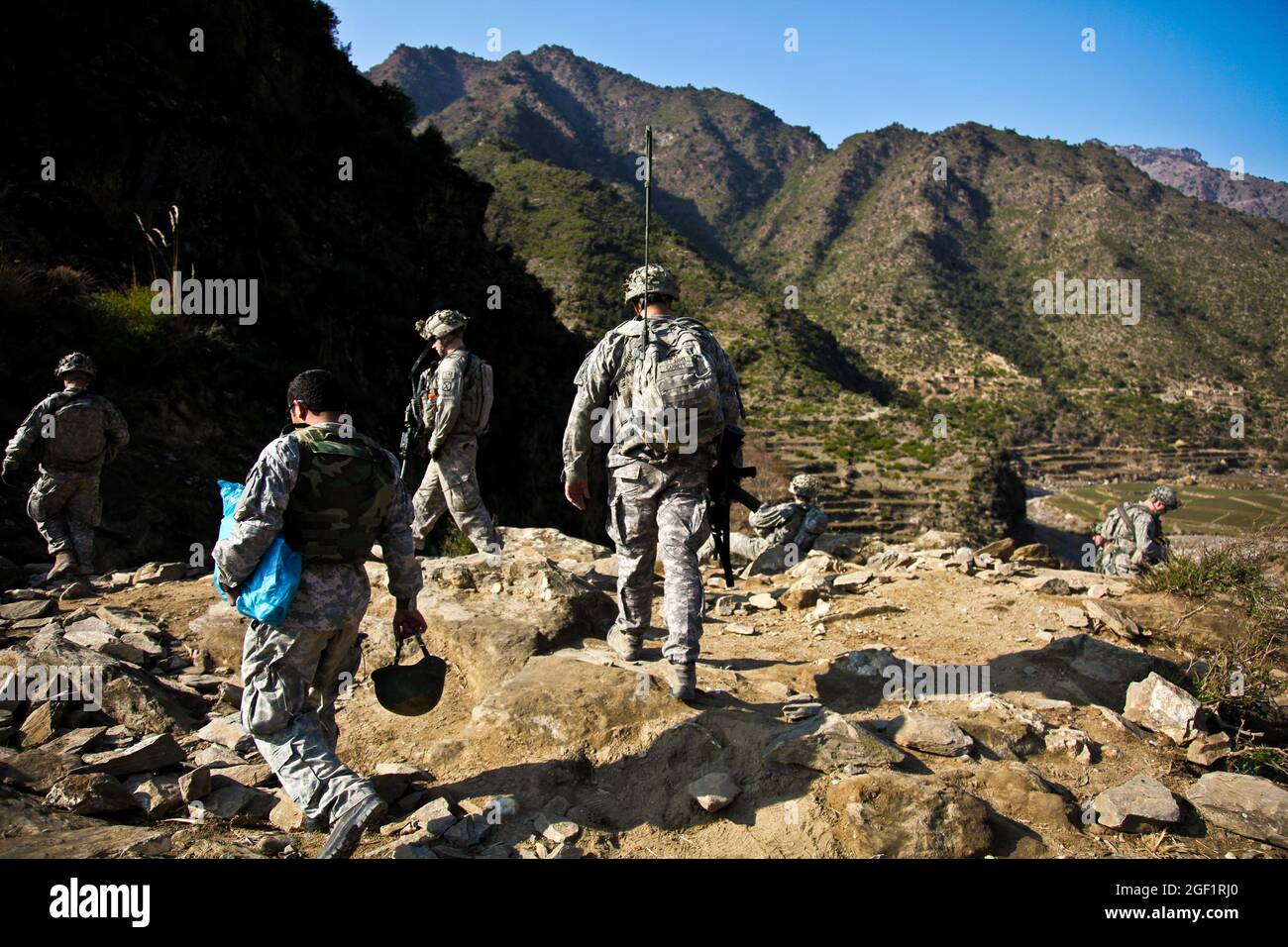 U.S. Army Soldiers assigned to Combat Company, 1st Battalion, 32nd Infantry Regiment, 3rd Brigade Combat Team, 10th Mountain Division, walk down to the Shigal Valley toward the village of Lachey in the Shigal district of Kunar province, Afghanistan on Dec. 7. Stock Photo