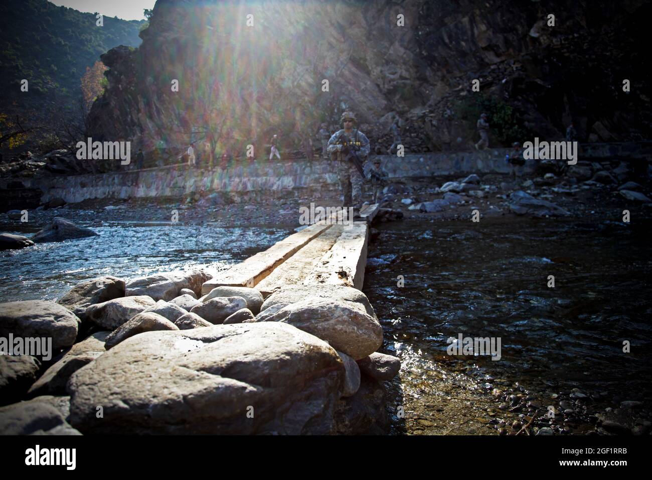 U.S. Army Soldiers assigned to Combat Company, 1st Battalion, 32nd Infantry Regiment, 3rd Brigade Combat Team, 10th Mountain Division, cross a river as they approach the village of Lachey in the Shigal district of Kunar province, Afghanistan on Dec. 7. Stock Photo