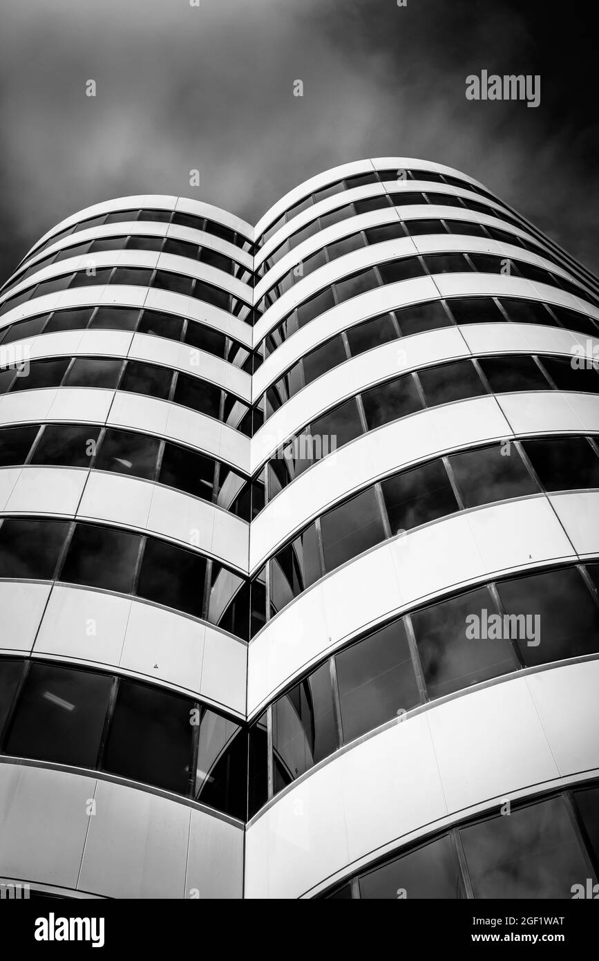 Modern styled high-rise city office building rising from street skyward in circular towers Stock Photo