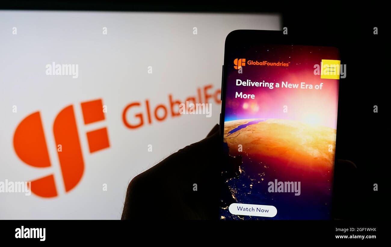 Person holding cellphone with website of US semiconductor company GlobalFoundries Inc. (GF) on screen with logo. Focus on center of phone display. Stock Photo