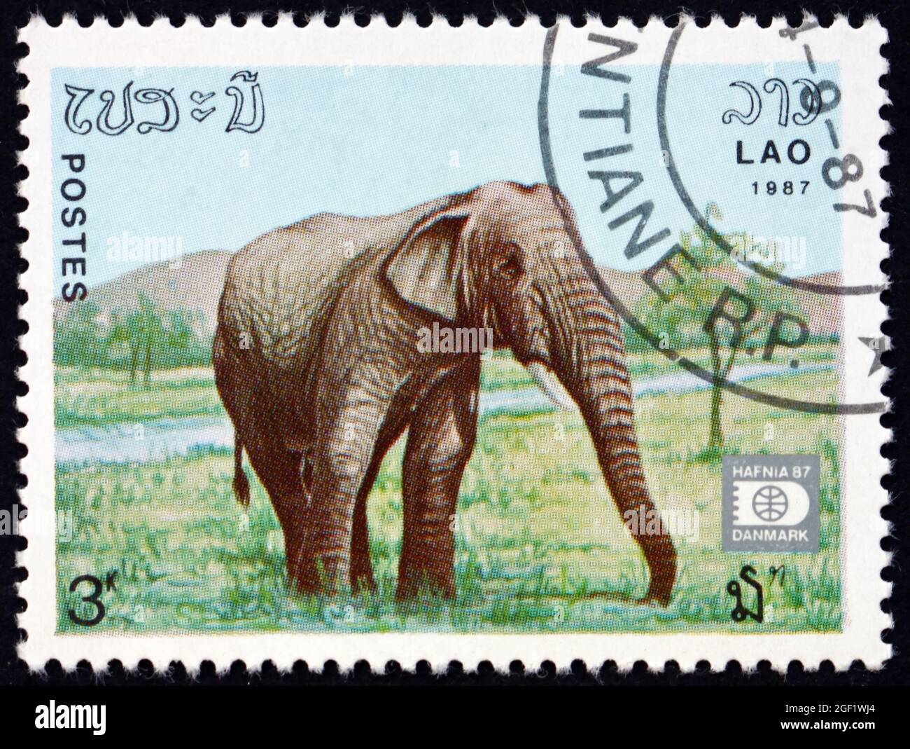 LAOS - CIRCA 1987: a stamp printed in Laos shows Indian elephant ...