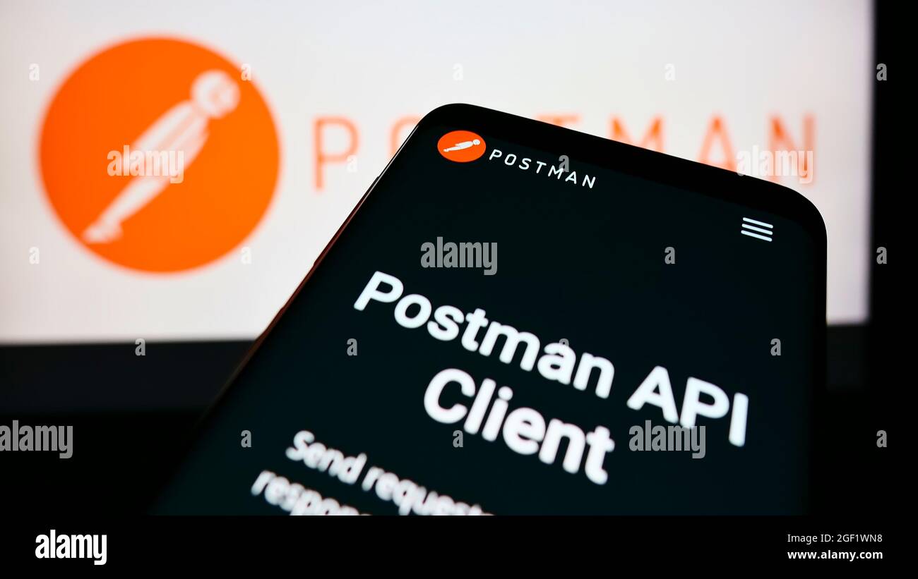 Mobile phone with webpage of American collaboration platform company Postman Inc. on screen in front of logo. Focus on top-left of phone display. Stock Photo