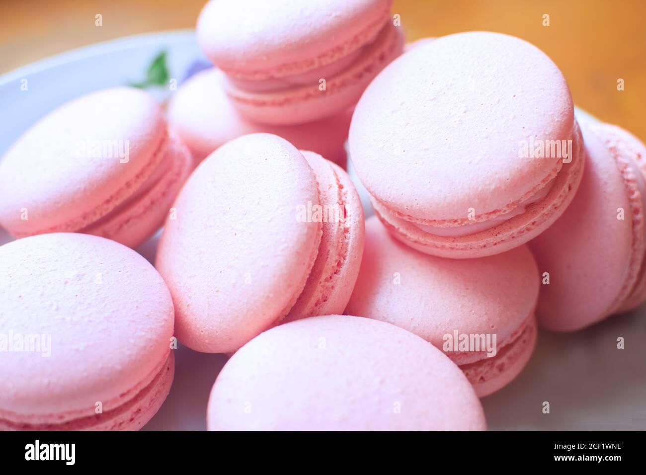 Sweet, tender and bright raspberries macarons on a white plate. Tasty french sweets. Stock Photo