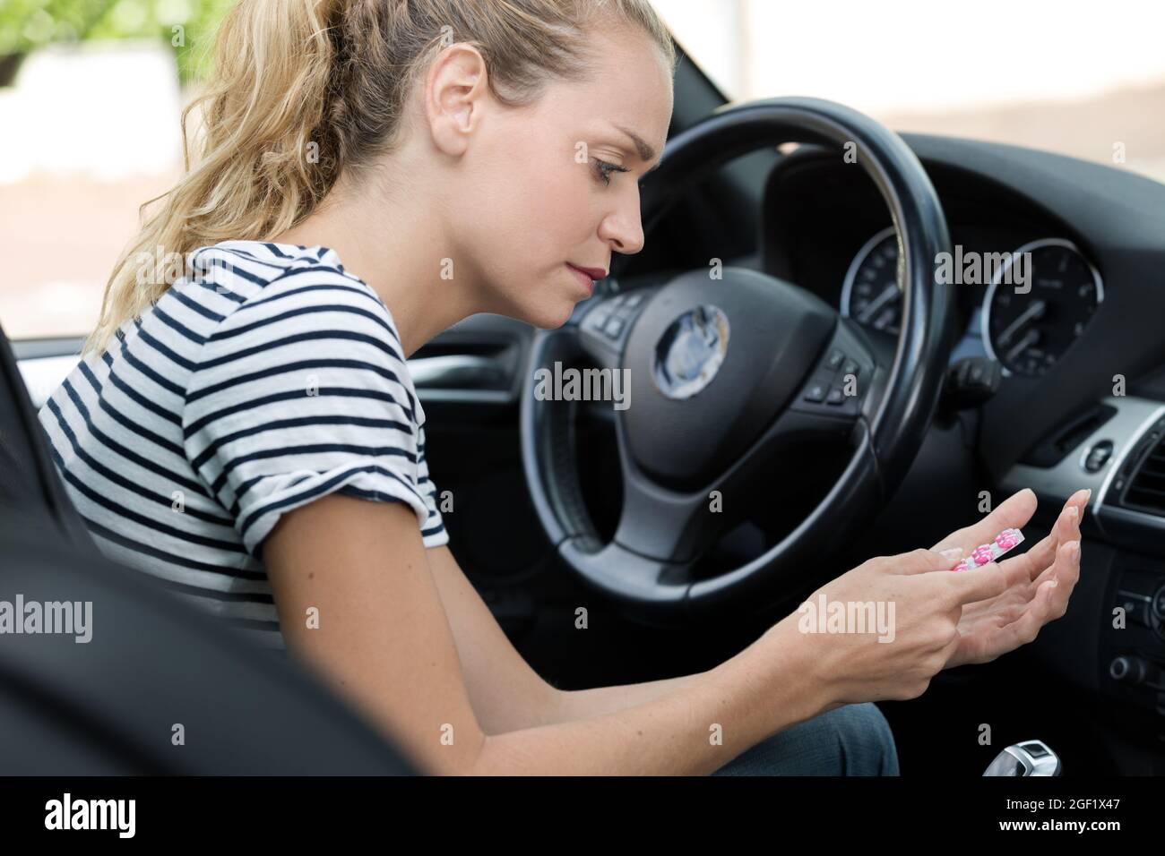 woman holds tablets while steering wheel of a car Stock Photo Alamy