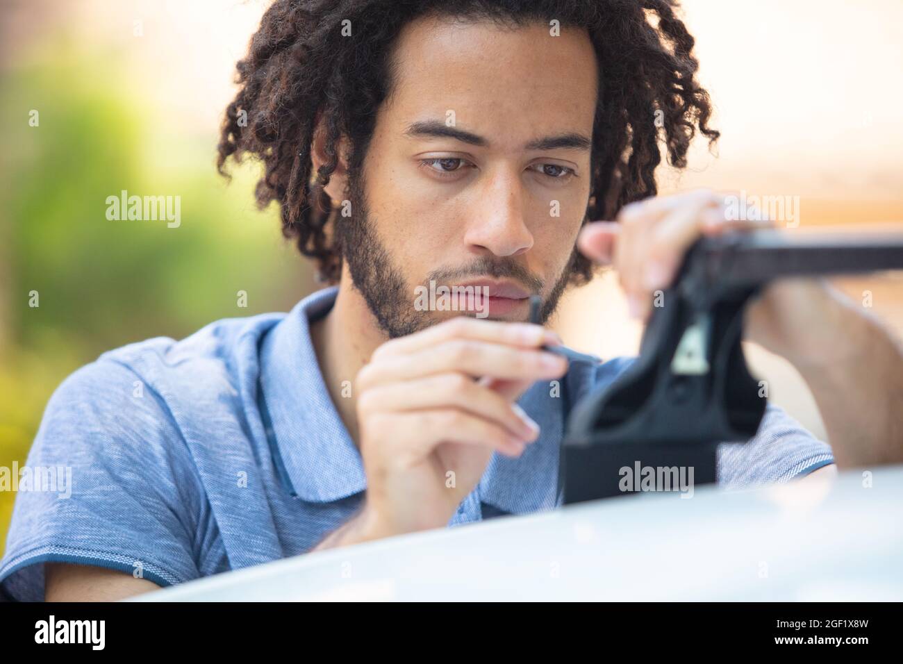 man fixing a car roof rack outdoors Stock Photo Alamy