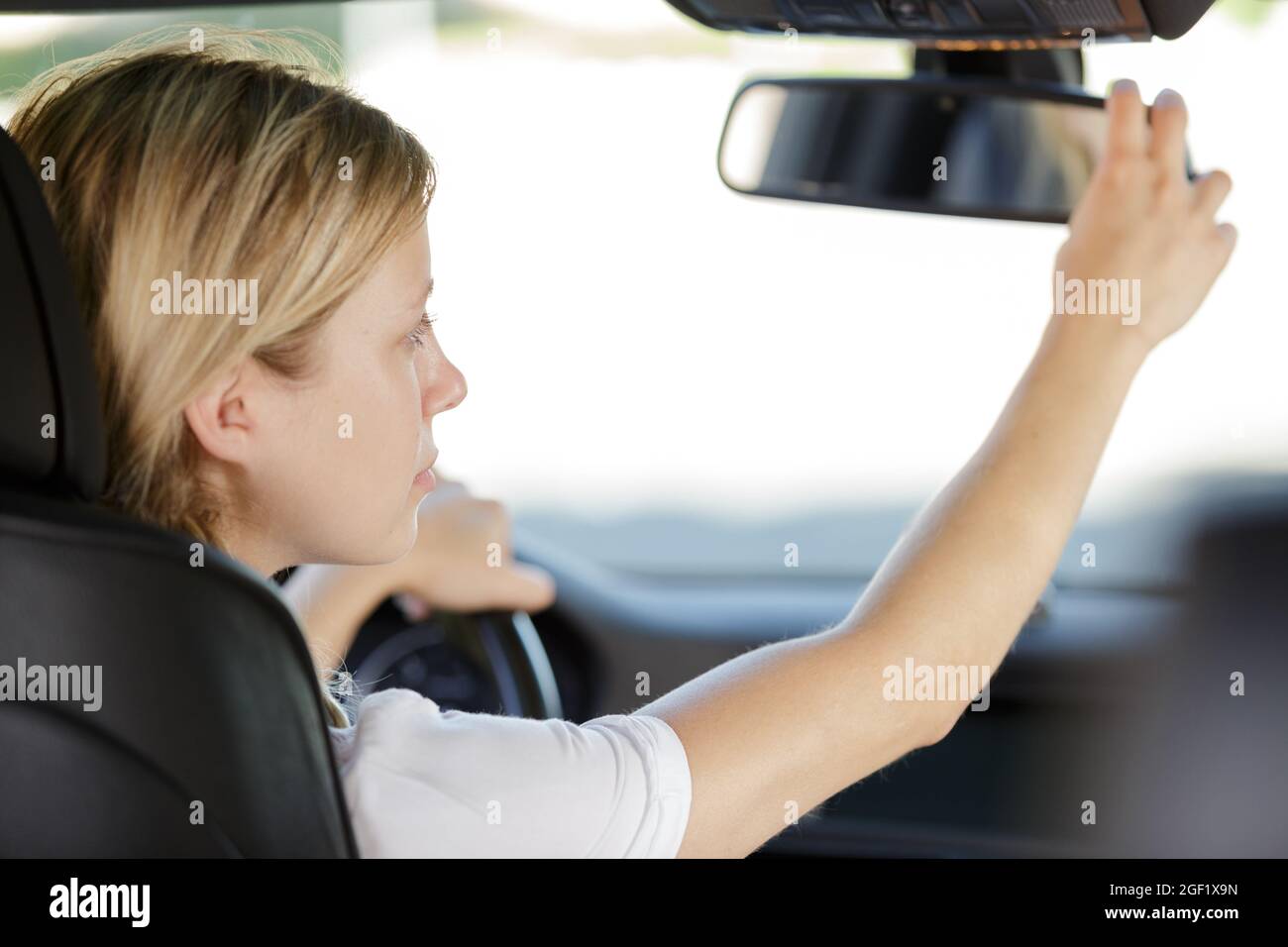 woman adjusting rear view mirror Stock Photo