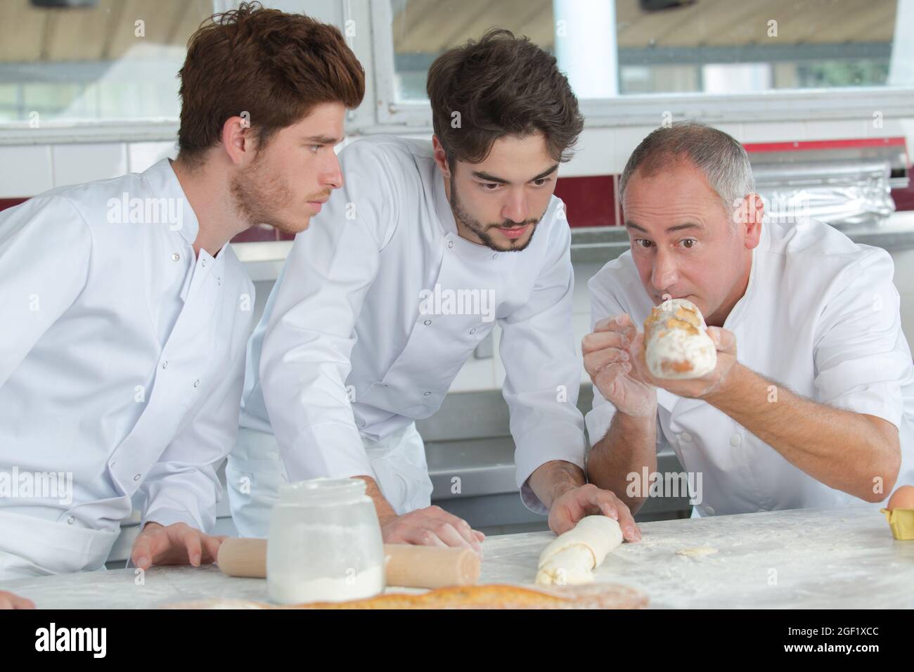 baker and his apprentice with a baguette bread Stock Photo Alamy