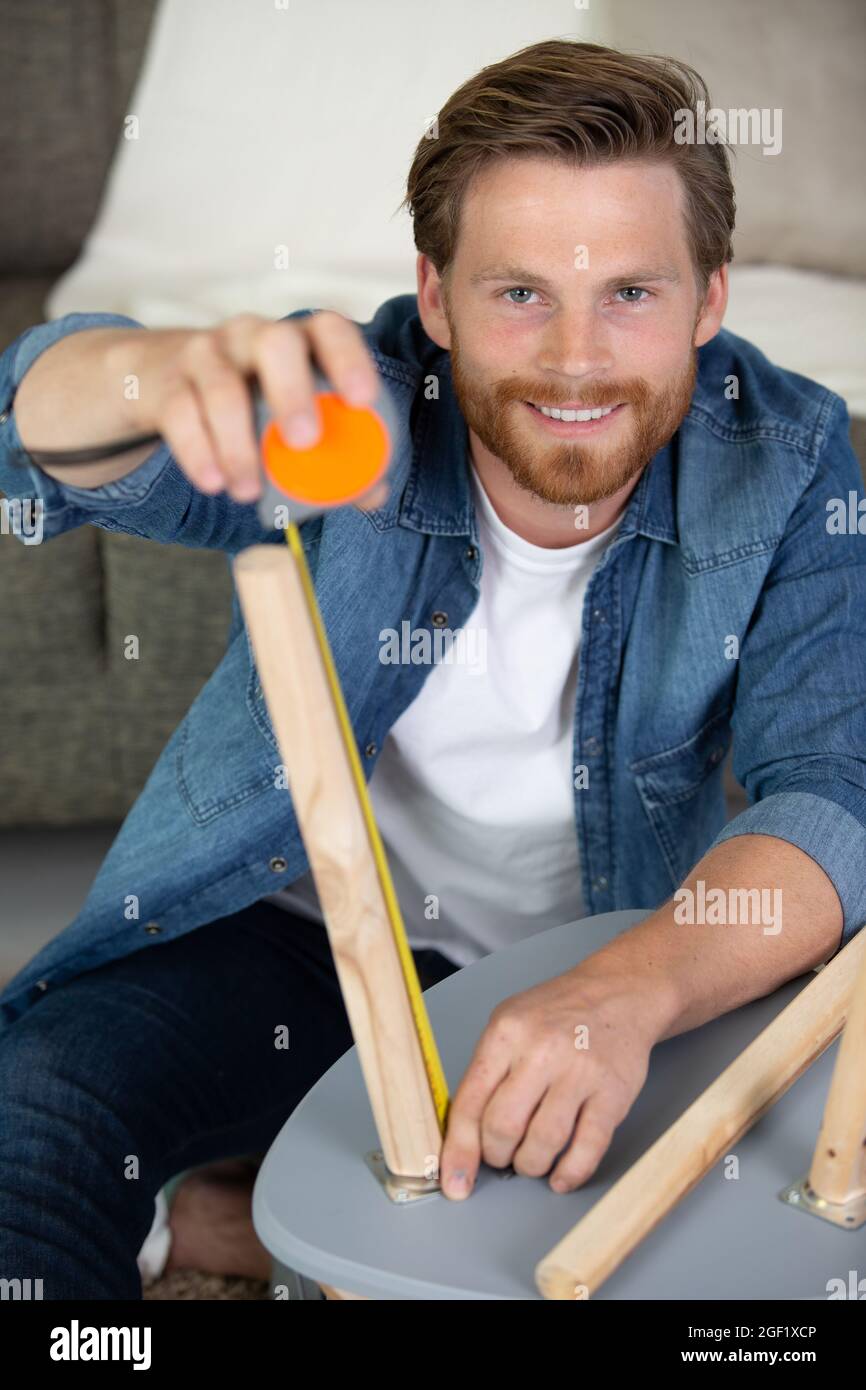 man using tape measure for measuring table legs Stock Photo Alamy