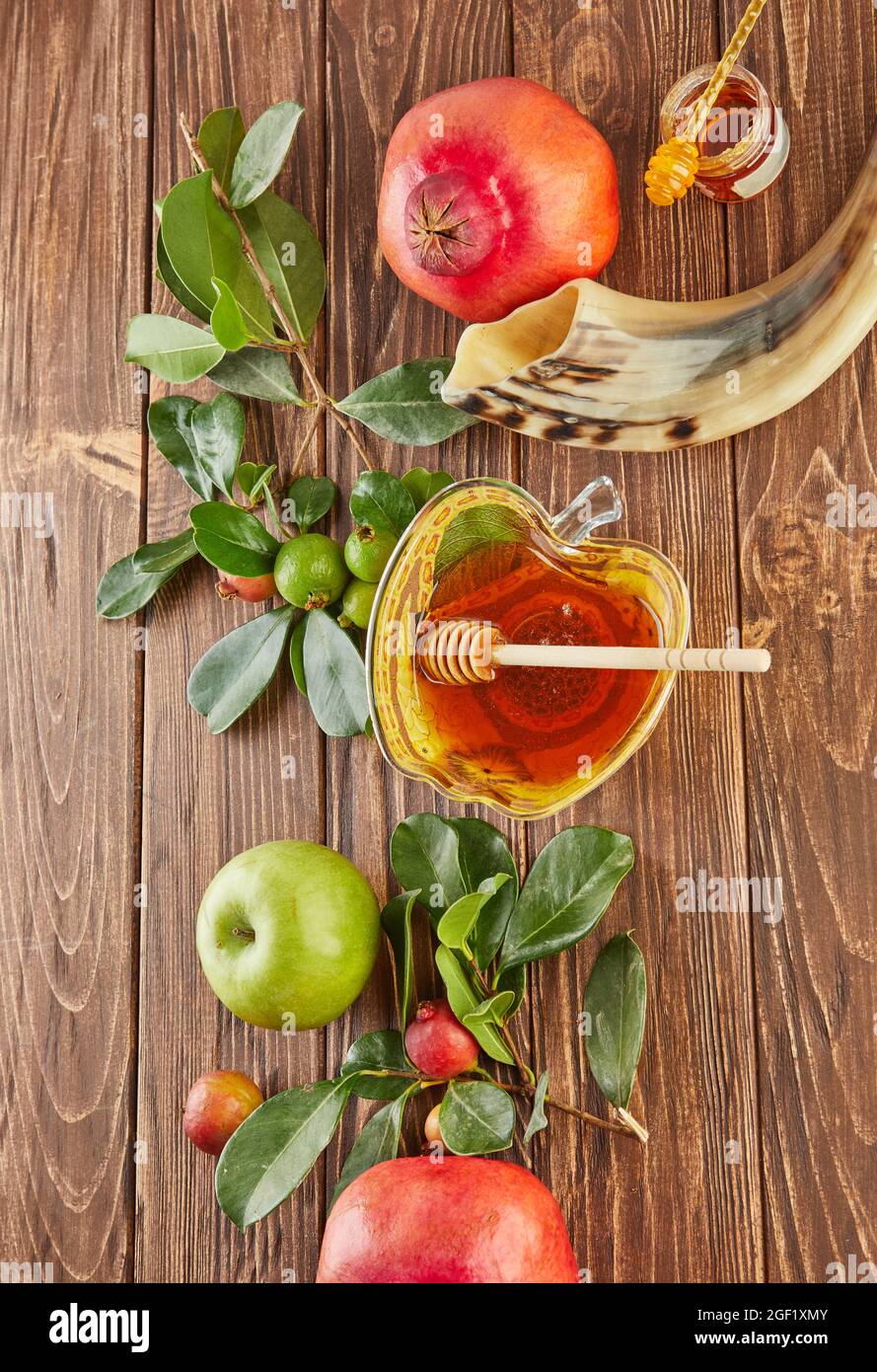 Rosh hashanah - jewish New Year holiday concept. A bowl in the shape of an apple with honey, pomegranate, shofar are traditional symbols of the holida Stock Photo