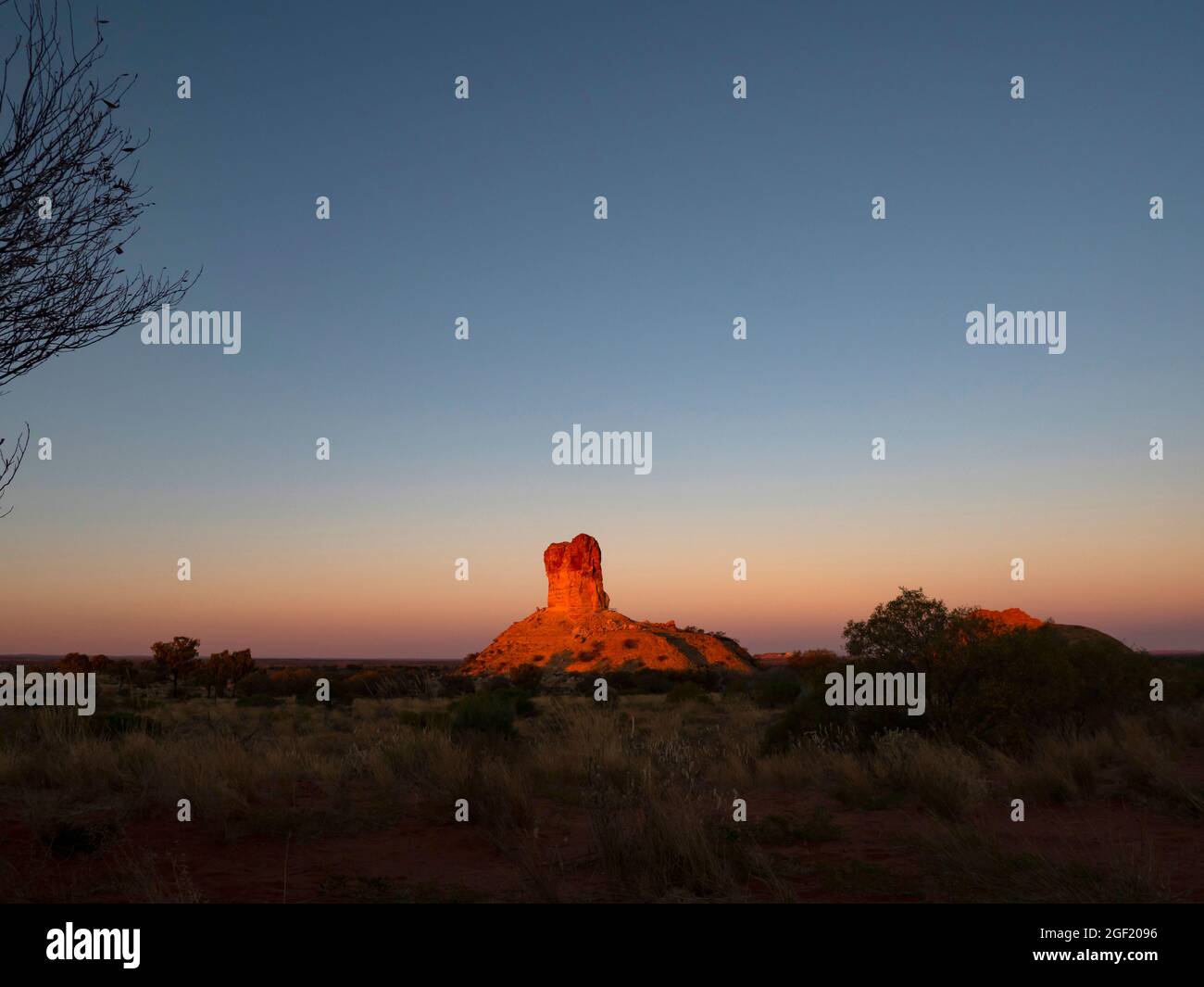 Chambers Pillar in Central Australia at sunset. Chambers Pillar is close to the geographic centre of Australia and was an important landmark for early Stock Photo