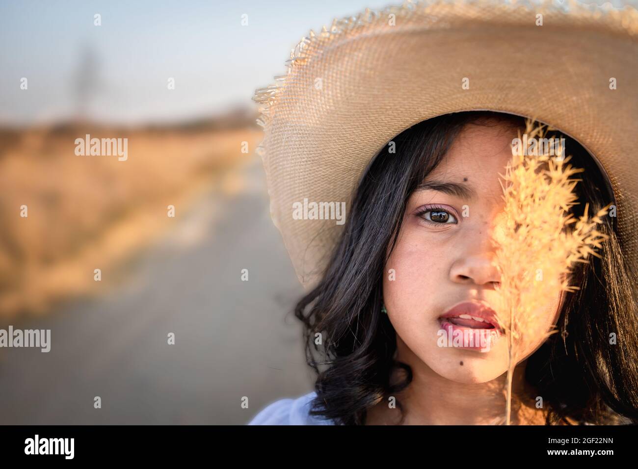 Portrait of a girl wearing a straw hat hires stock photography and