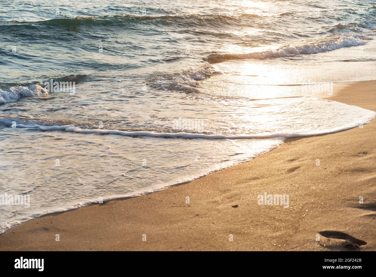 Beach sand and sea waves on sunset Stock Photo - Alamy