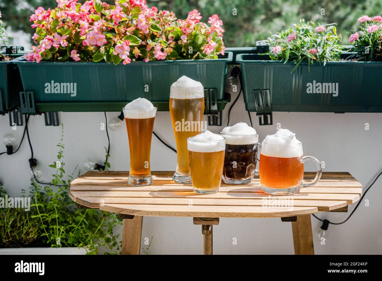 Beer glasses on wooden table at green balcony Stock Photo