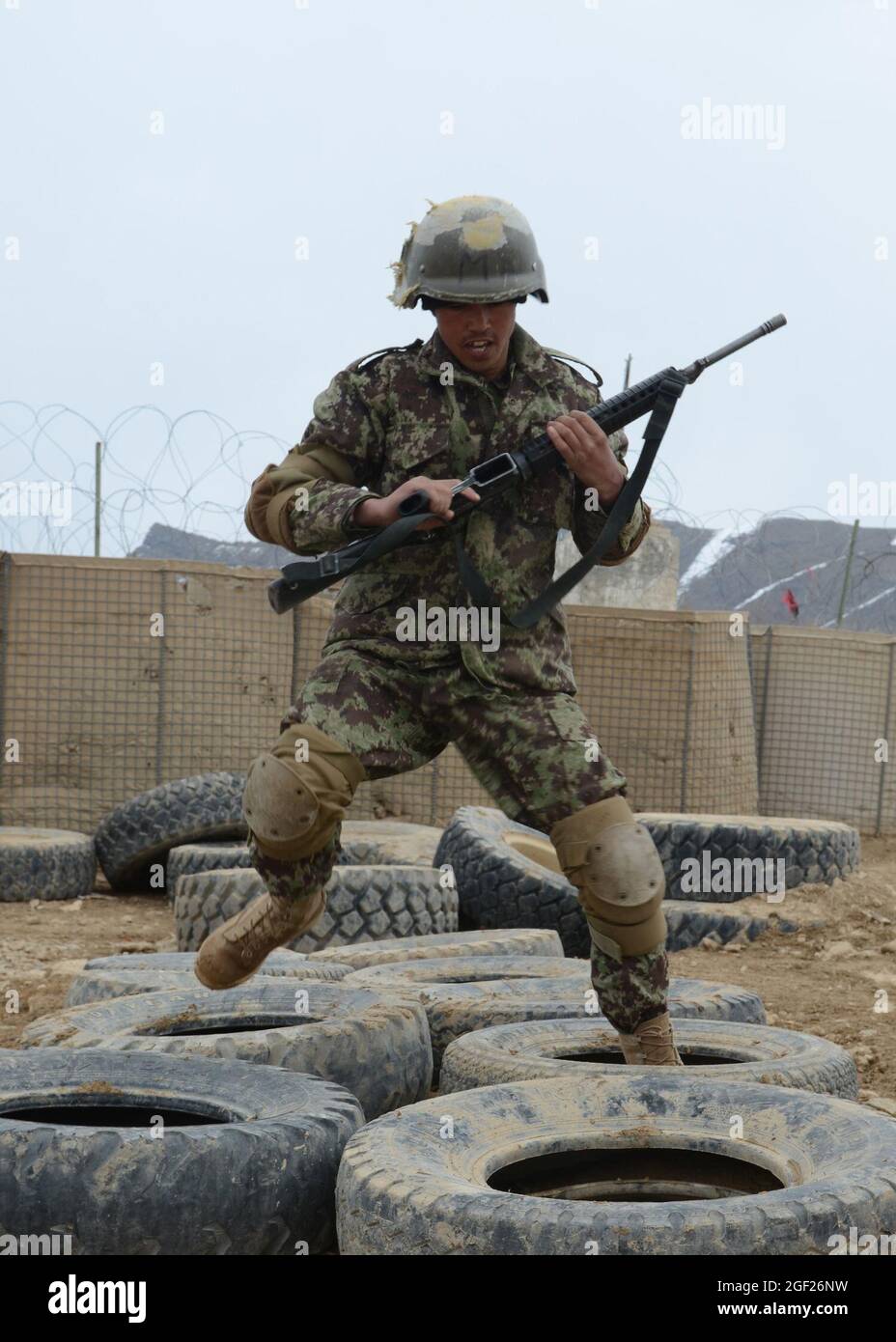 PAKTYA PROVINCE, Afghanistan –An Afghan National Army basic trainee runs through tires during an obstacle course at the Regional Military Training Center of Gardez, Feb. 25, 2013. The nine-week basic training course will graduate approximately 600 future ANA soldiers. (U.S. Army photo by Spc. Tianna Waite, 115th Mobile Public Affairs Detachment) Stock Photo