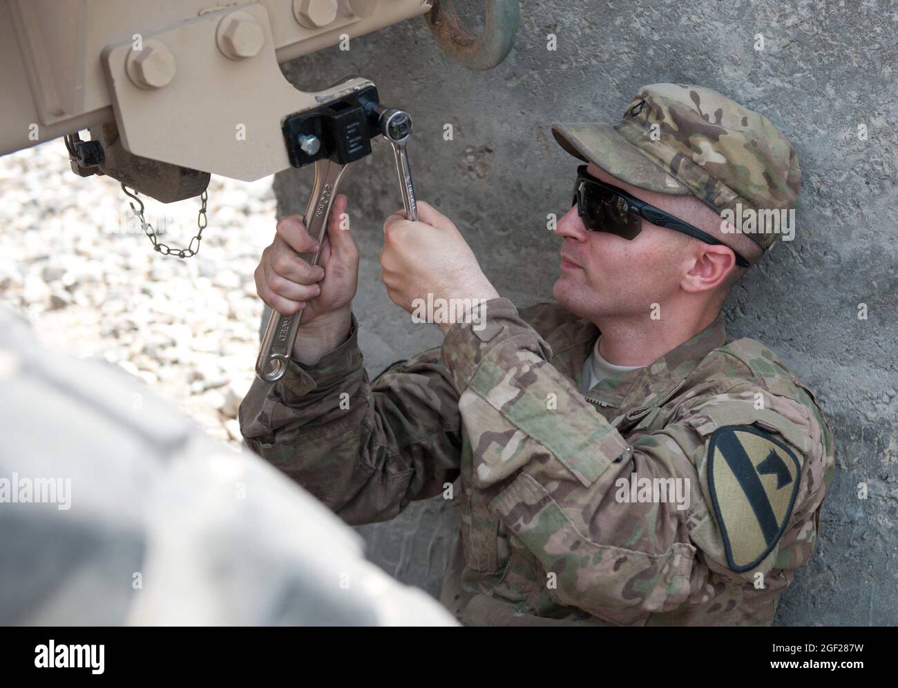 U.S. Army Pfc. Nathan Weber, of Smyrna, Del., a wheeled vehicle mechanic with Troop D, 4th Squadron, 9th Cavalry Regiment, 2nd Brigade Combat Team, 1st Cavalry Division, tightens a bolt on a truck at Forward Operating Base Fenty, Nangarhar province, Afghanistan, Sept. 11, 2013. Troop D's ongoing mission at Fenty is the maintenance, recovery and repair of everything from portable generators to vehicles disabled by roadside explosives. (U.S. Army National Guard photo by Sgt. Margaret Taylor, 129th Mobile Public Affairs Detachment/RELEASED) Stock Photo