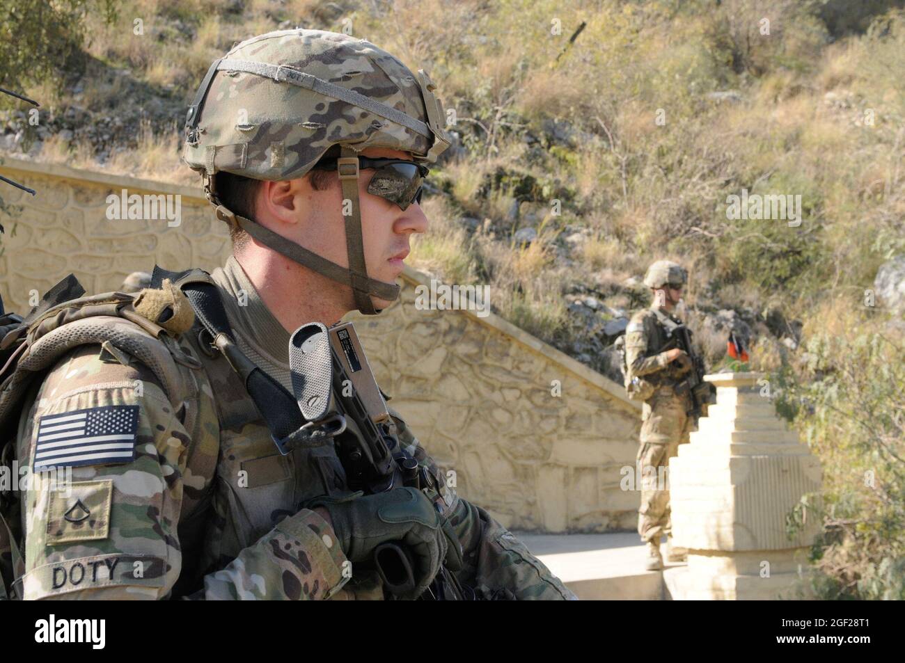 U.S. Army Spc. Andrew Doty (left), of Poquoson, Va., and Spc. Joshua Provo (right) from Festus, Mo., overlook the Afghanistan/Pakistan border at Torkham, Nov. 19, 2013, while their superiors discuss customs and security operations at the border in order to gain a better understanding of how the Afghan Border Police protect their country against illegal immigration and smuggling. Both men serve as infantrymen with Company C, 2nd Battalion, 30th Infantry Regiment, 4th Brigade Combat Team, 10th Mountain Division. (U.S. Army Photo by Sgt. Eric Provost, Task Force Patriot PAO) Stock Photo