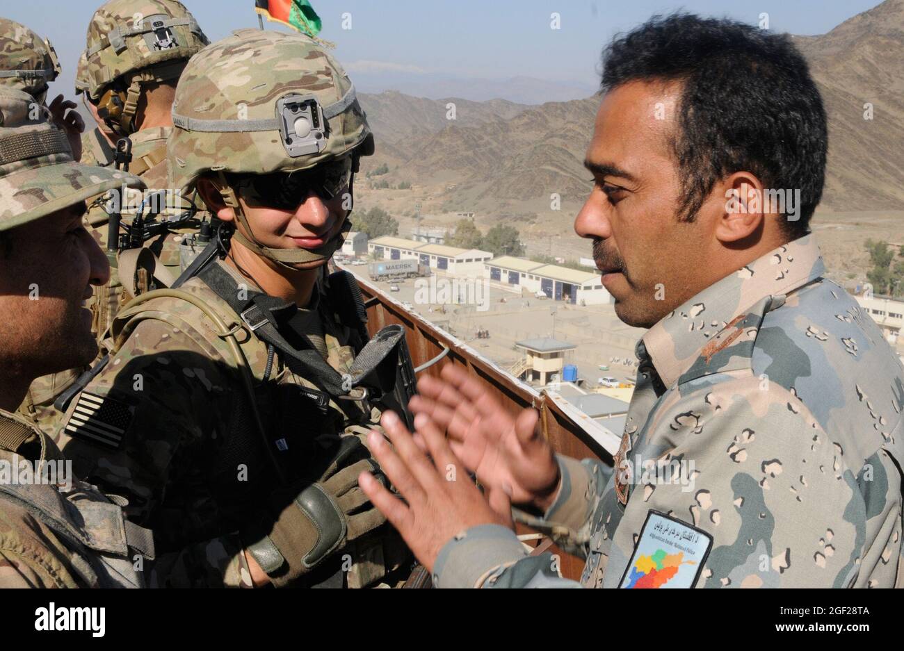 U.S. Army 2nd Lt. Michael Sardinas, platoon leader (center), Company C, 2nd Battalion, 30th Infantry Regiment, 4th Brigade Combat Team, 10th Mountain Division, from Tampa, Fla., discusses operations with an Afghan Border Police officer, Nov. 19, 2013, while standing on a vantage point above the Afghanistan/Pakistan border at Torkham. Sardinas and others visited the border to get better situational awareness of the techniques and procedures the ABP use to help secure this critical supply route for NATO forces and the people of Afghanistan. (U.S. Army Photo by Sgt. Eric Provost, Task Force Patri Stock Photo