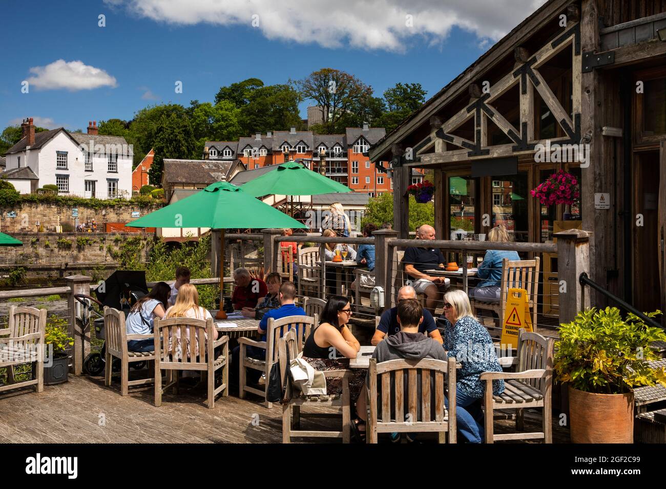 UK Wales, Clwyd, Llangollen, Old Corn Mill, (Melin Yd) cafe beside River Dee, customers in sunshine Stock Photo