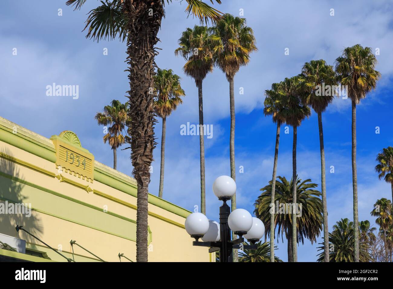 Napier, New Zealand. One of the town's Art Deco buildings inscribed '1934' and the palm trees of Clive Square Stock Photo