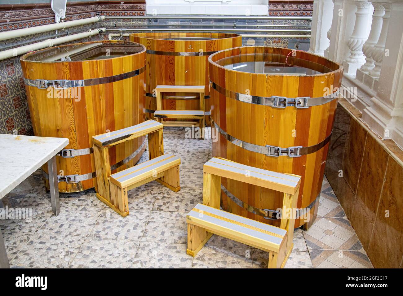 Western style wooden bathtubs in barrel shape. Spa treatments barrels cedar bath in wooden decoration. Wood buckets Stock Photo