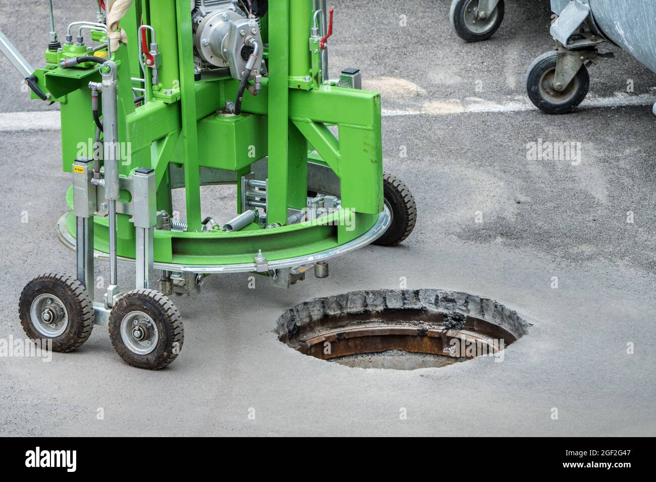 a manhole cover is milled in the street with a special machine, Sewer work, Canal work, Duct work, Road construction Stock Photo