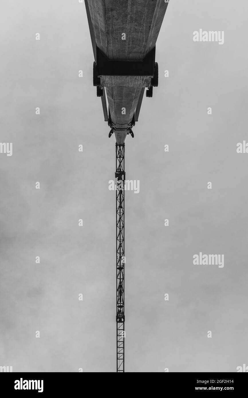 Grayscale shot of crane against a grey sky Stock Photo
