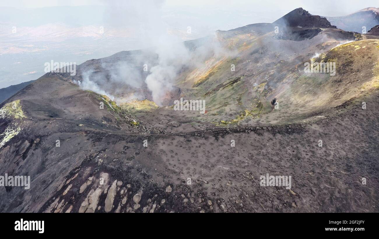 Crater Etna top view from above in a panoramic aerial photo with sulphure and smoke at degassation Stock Photo