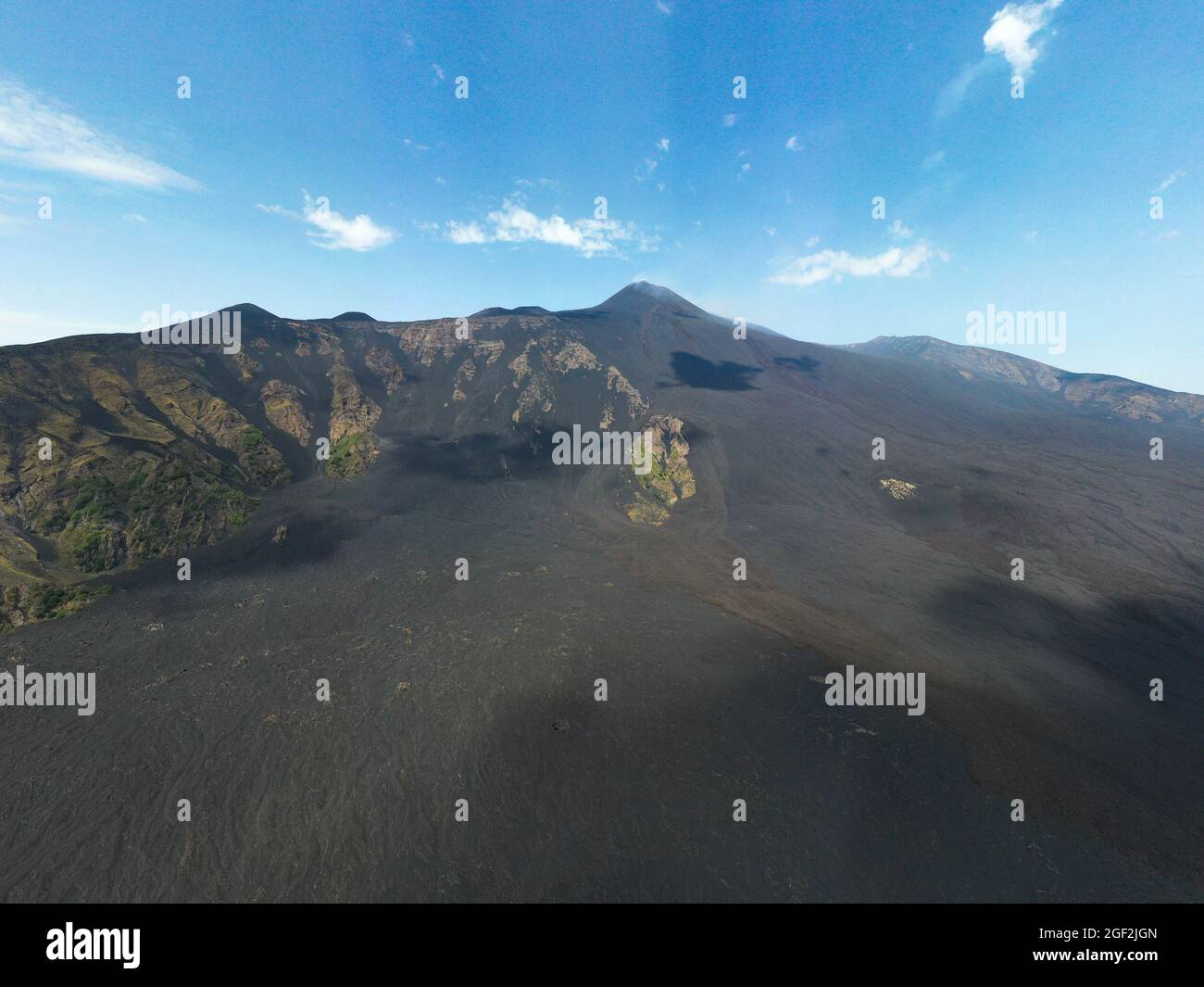 Bove Valley-Valle del Bove on Etna Volcano in a spectacular aerial panoramic view from above with top crater and blue sky in background Stock Photo