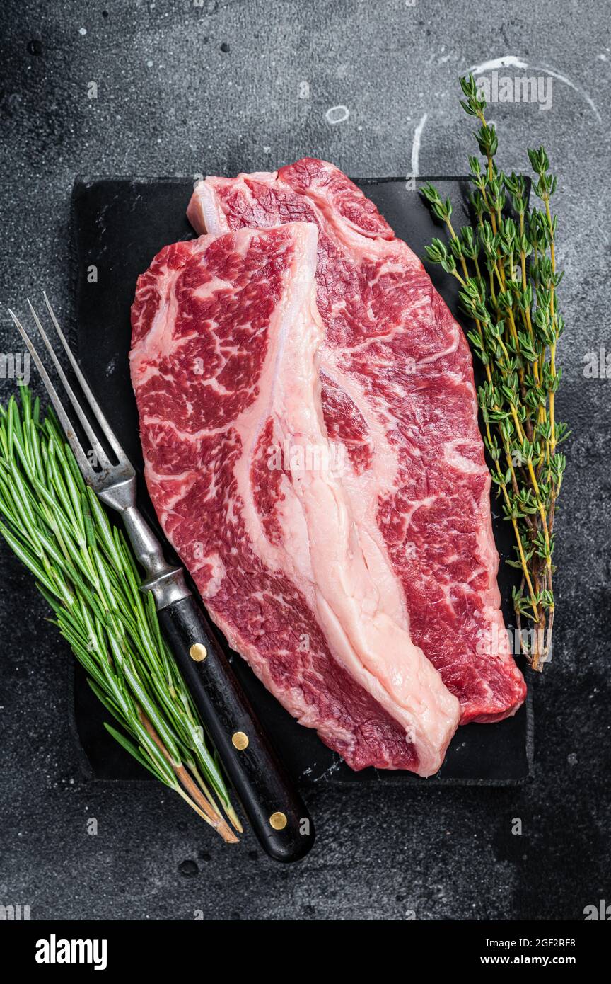 Raw Striploin steak or New York steak beef meat cut. Black background