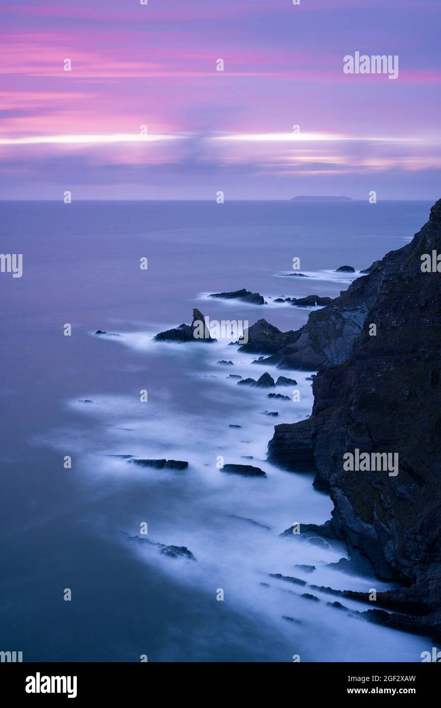 The rugged coastline at Hartland Quay from the top of Warren Cliff on the North Devon Coast Area of Outstanding Natural Beauty with Lundy Island on the horizon, England. Stock Photo