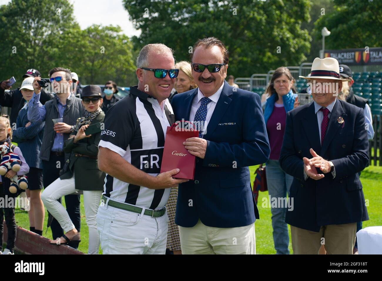 Egham, Surrey, UK. 23rd August, 2021. Umpire Tim Brown is presented with a Cartier gift by John Collins, CEO and Founder of Talacrest after the Talacrest Prince of Wales's Championship Cup Sub-Final. Bardon Polo Team beat the UAE Polo Team. Credit: Maureen McLean/Alamy Stock Photo