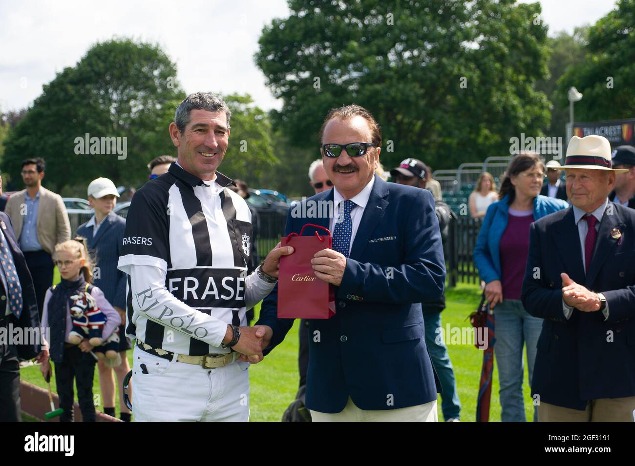 Egham, Surrey, UK. 23rd August, 2021. Umpire Julian Appleby is presented with a Cartier gift by John Collins, CEO and Founder of Talacrest after the Talacrest Prince of Wales's Championship Cup Sub-Final. Bardon Polo Team beat the UAE Polo Team. Credit: Maureen McLean/Alamy Stock Photo