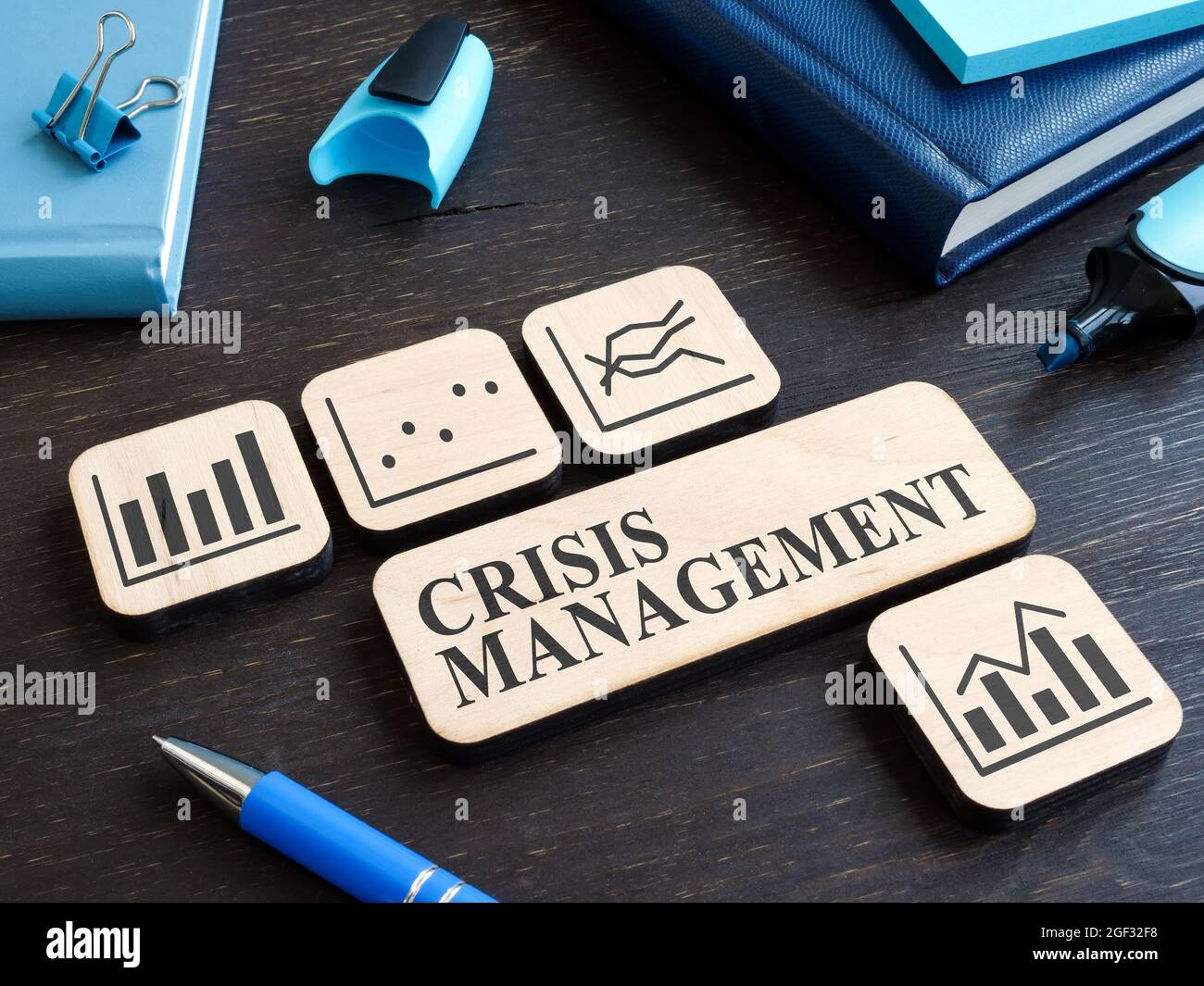 Crisis management on the wooden plate and plates with charts. Stock Photo