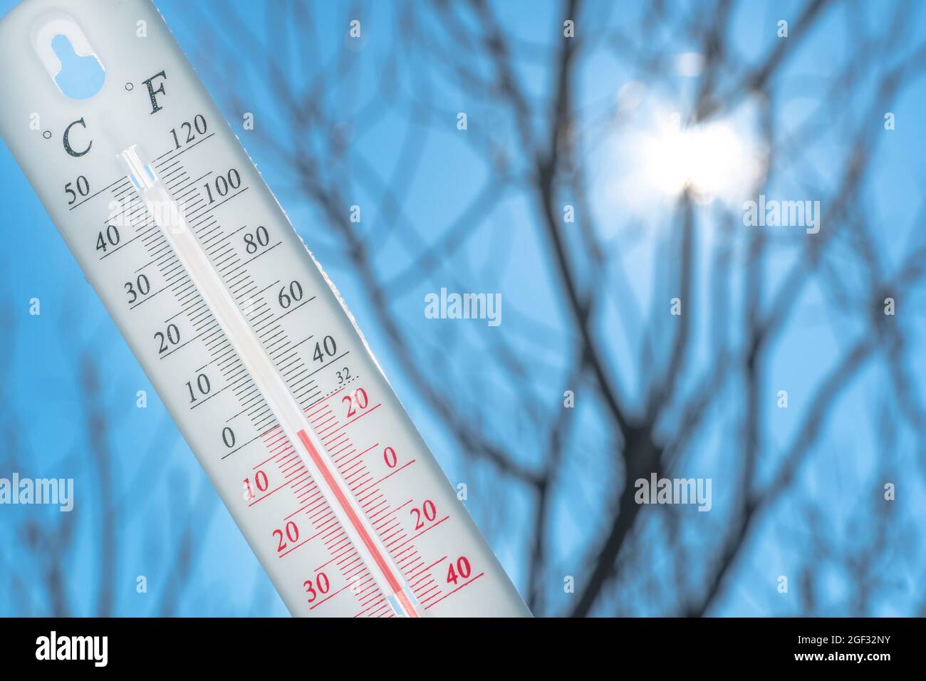The thermometer lies on the snow and shows a negative temperature in cold weather on the blue sky.Meteorological conditions with low air and ambient t Stock Photo
