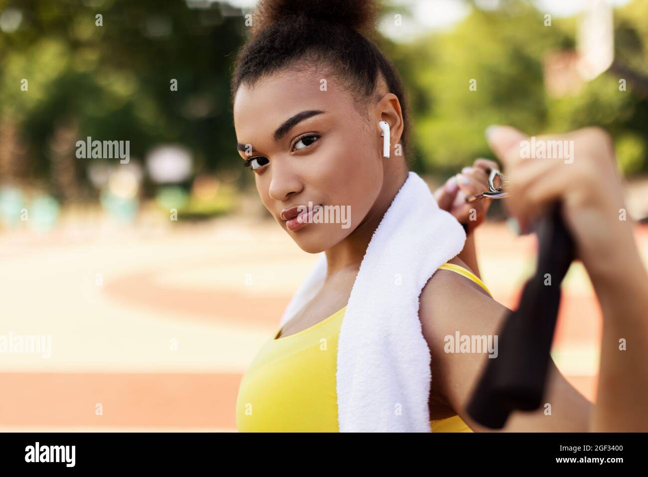 Sporty black woman in yellow sportswear looking at camera Stock Photo ...