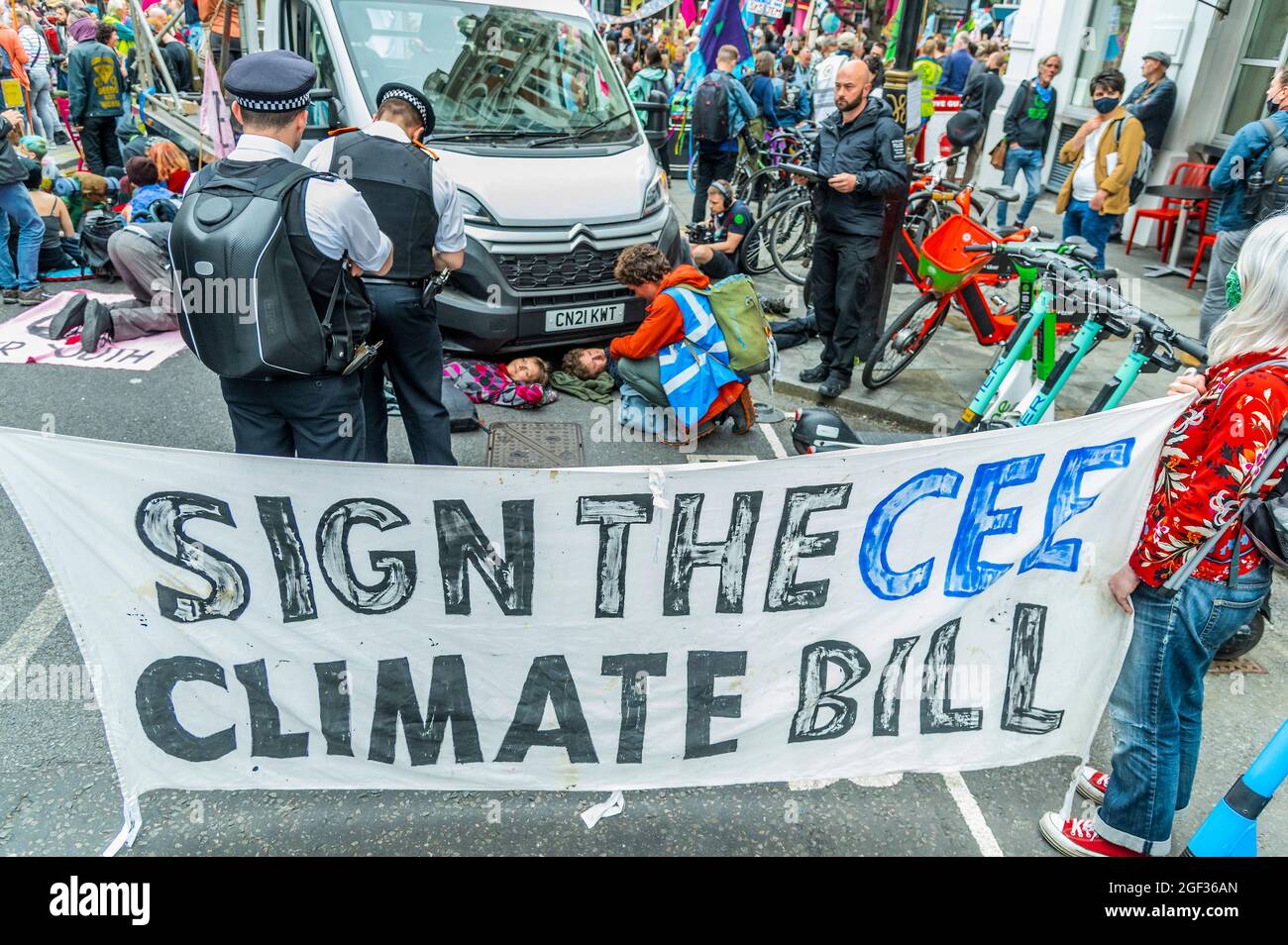 London, UK. 23rd Aug, 2021. People glue themselves to a vehicle to