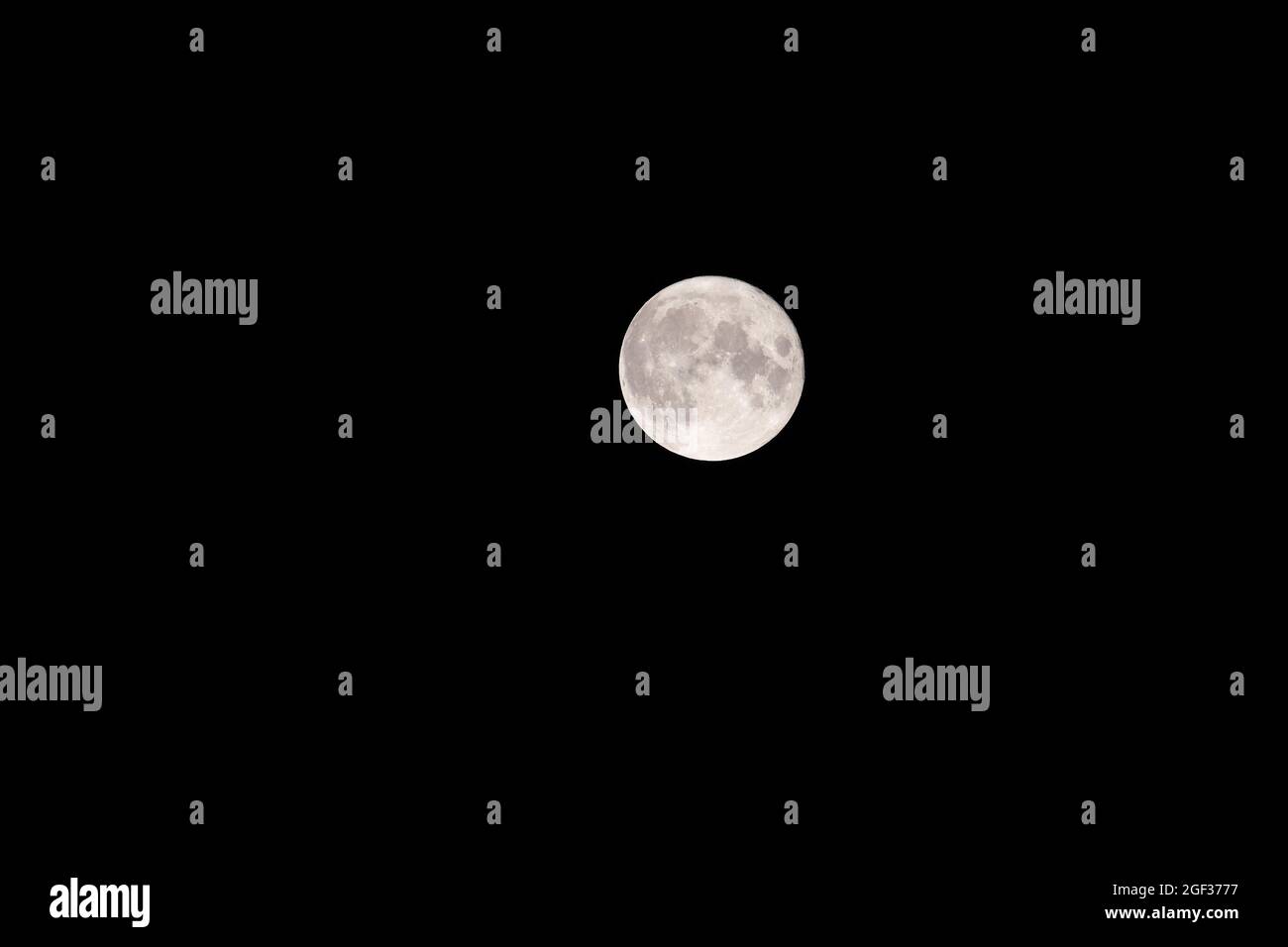 A full moon pictured late in the evening of 22nd August, 2021. This moon is commonly kown as a blue moon; the third full moon in an astronomical seaso Stock Photo