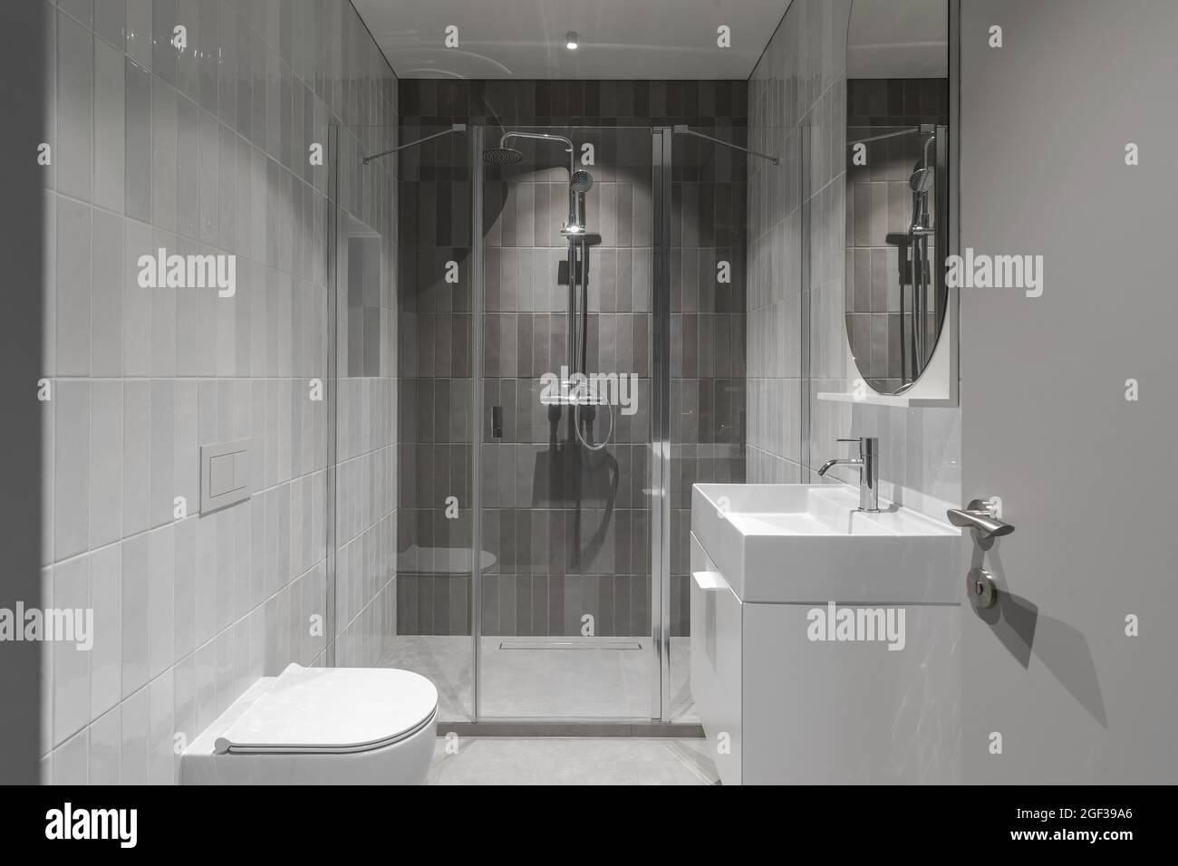 Modern furnished  minimalist bathroom light grey interior design with metro style grey tiles Stock Photo
