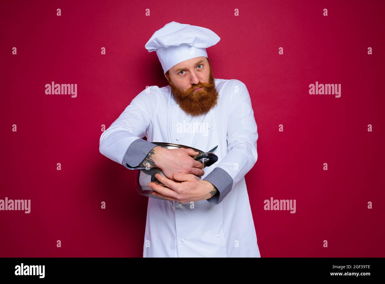 chef with beard and red apron is jealous of his recipe Stock Photo