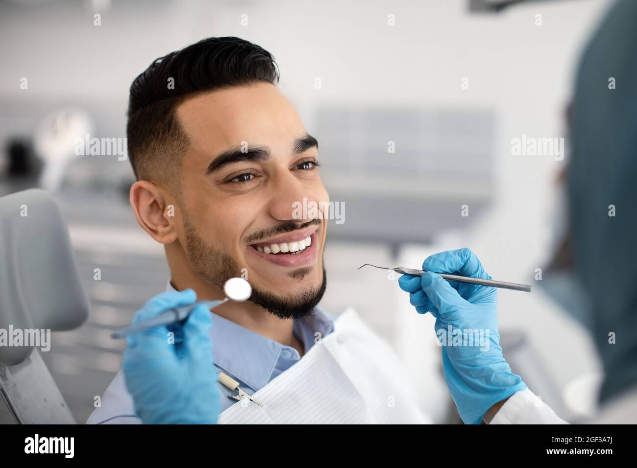 Closeup Of Happy MiddleEastern Male Patient Getting Dental Treatment