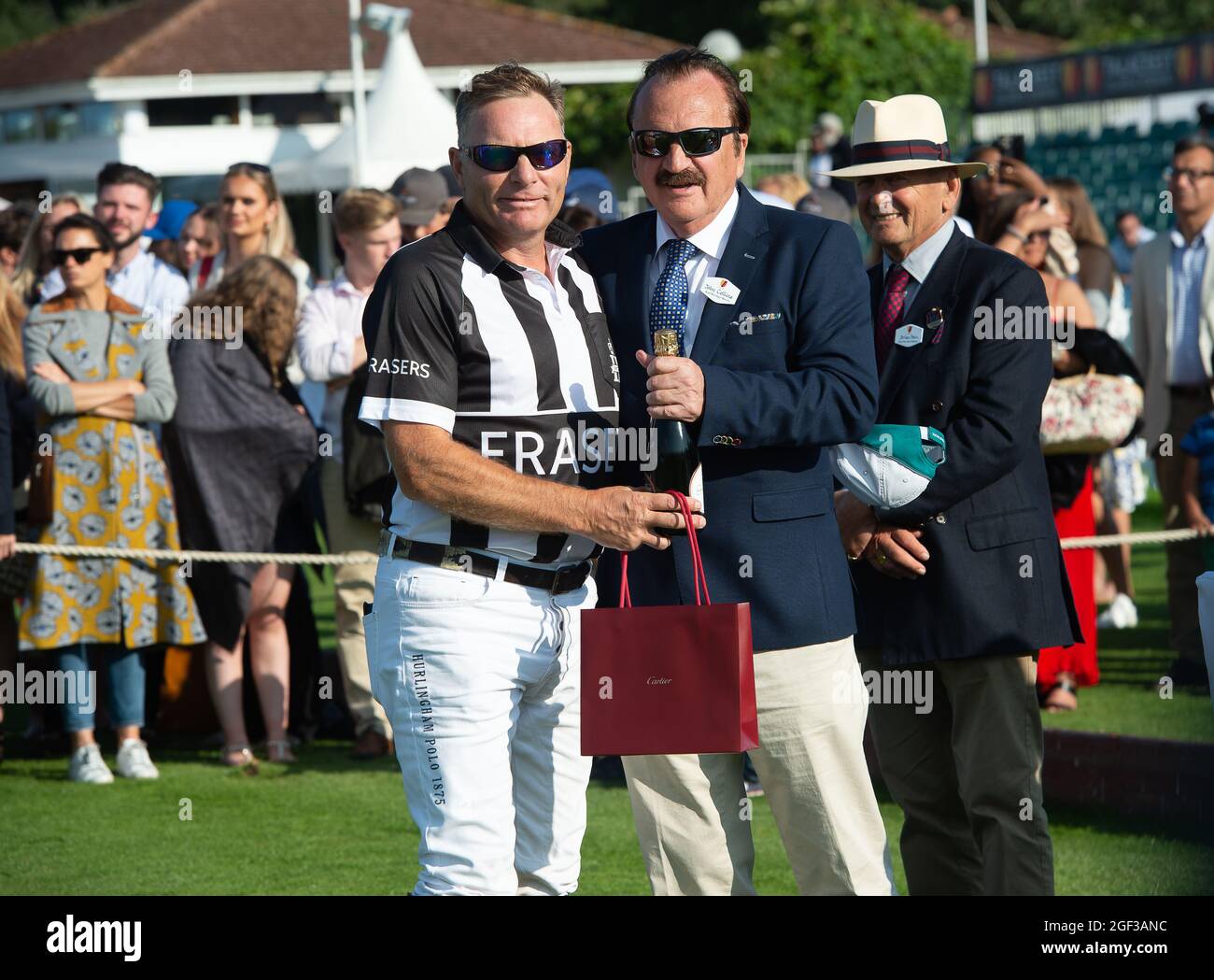 Egham, Surrey, UK. 22nd August, 2021. Polo umpire Jason Dixon gets his Cartier gift and champagne from John Collins CEO and Founder of Talacrest after umpiring in the Talacrest Prince of Wales's Championship Cup Final at Guards Polo Club. Credit: Maureen McLean/Alamy Stock Photo