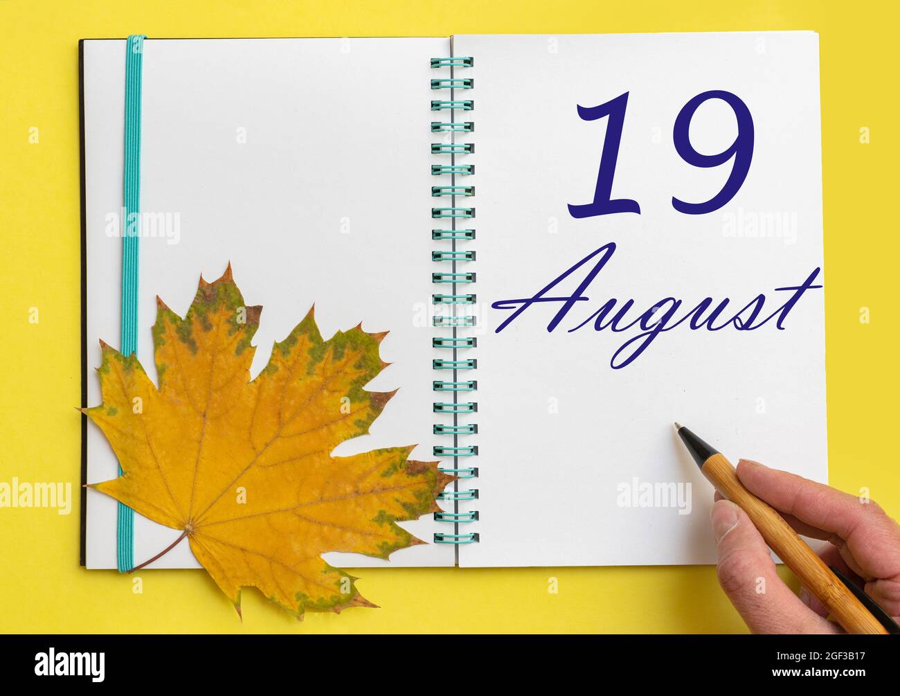 19th day of august. Hand writing the date 19 august in an open notebook ...