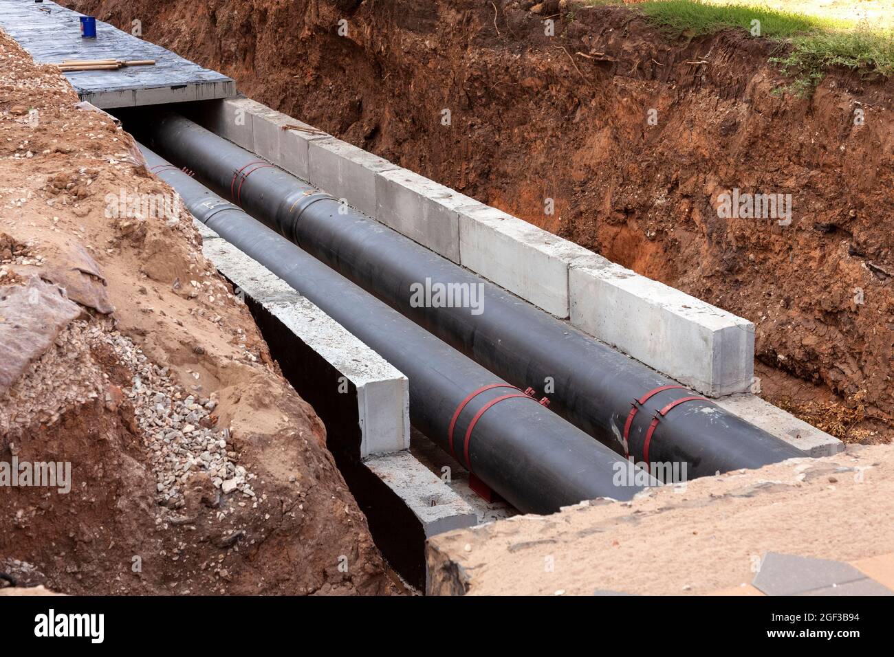 Insulated pipes in the trench. Water main reconstruction and replacement. Stock Photo
