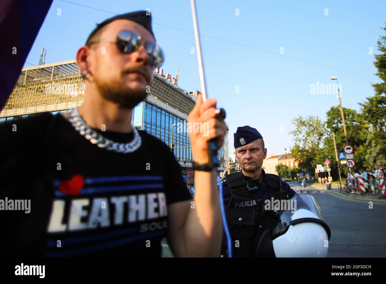A riot policeman is seen standing while being passed by a member of a leather gay community during the march.  Annual Equality March also known as 'Pr Stock Photo