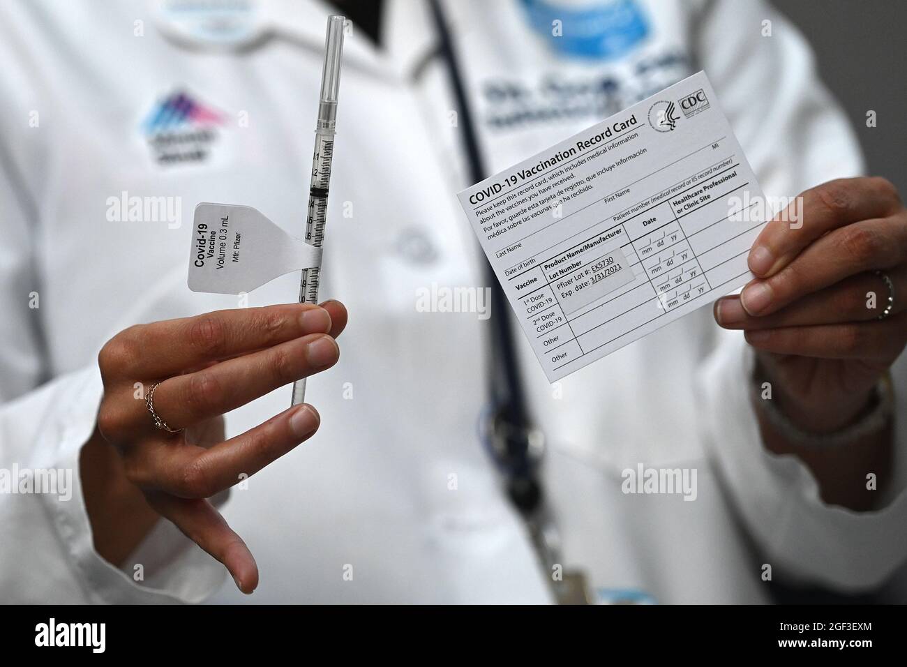 A medical professional holds a syringe containing the Pfizer COVID-19 vaccine and a proof of vaccine card before it is administered to a medical professional at Mount Sinai Hospital in New York, NY, December 15, 2020. Mount Sinai received enough Pfizer COVID-19 vaccine doses to inoculate 975 members of their medical staff.   (Photo by Anthony Behar/Sipa USA) Stock Photo
