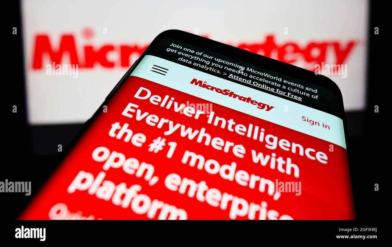 Mobile phone with webpage of American software company MicroStrategy Inc. on screen in front of business logo. Focus on top-left of phone display. Stock Photo